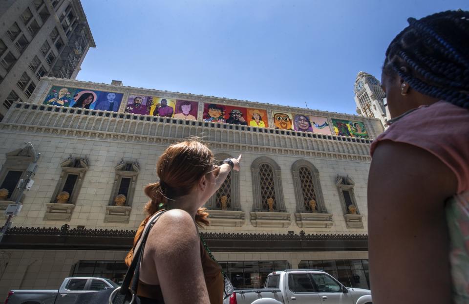 A woman, left, points to a building.