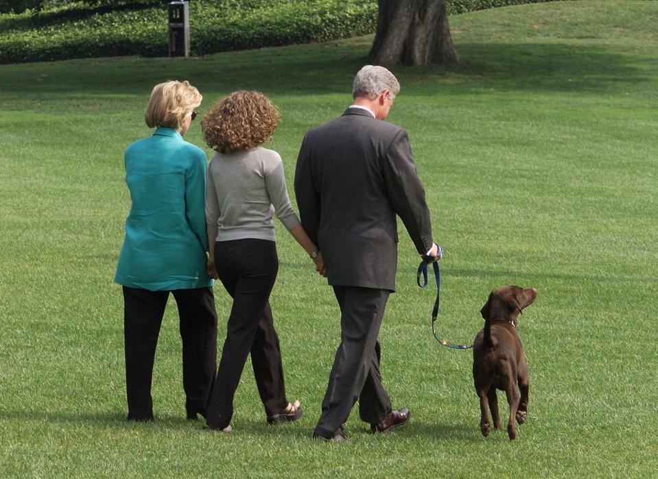 President Bill Clinton (R), First Lady Hillary Clinton (L), and their daughter Chelsea (C) depart the White House in Washington, DC, with their dog Buddy on their way to a two-week vacation in Martha's Vineyard, Massachusetts on Aug. 18, 1998.  Clinton gave a televised address 17 August to the American people from the White House regarding his testimony earlier 17 August to a federal grand jury in which he admitted to an improper relationship with former White House intern Monica Lewinsky.  (Photo: Luke Frazza/AFP via Getty Images)