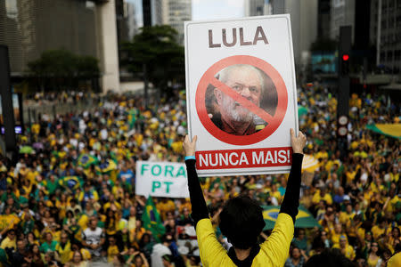 Supporter of Jair Bolsonaro, far-right lawmaker and presidential candidate of the Social Liberal Party (PSL), holds a sign with the image of former Brazilian president Luiz Inacio Lula da Silva reading "Lula, never again" during a demonstration in Sao Paulo, Brazil, October 21, 2018. REUTERS/Nacho Doce