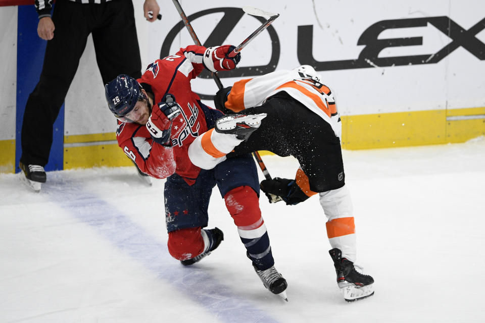 Washington Capitals center Nic Dowd (26) and Philadelphia Flyers center Scott Laughton, right, collide during the first period of an NHL hockey game Saturday, May 8, 2021, in Washington. (AP Photo/Nick Wass)