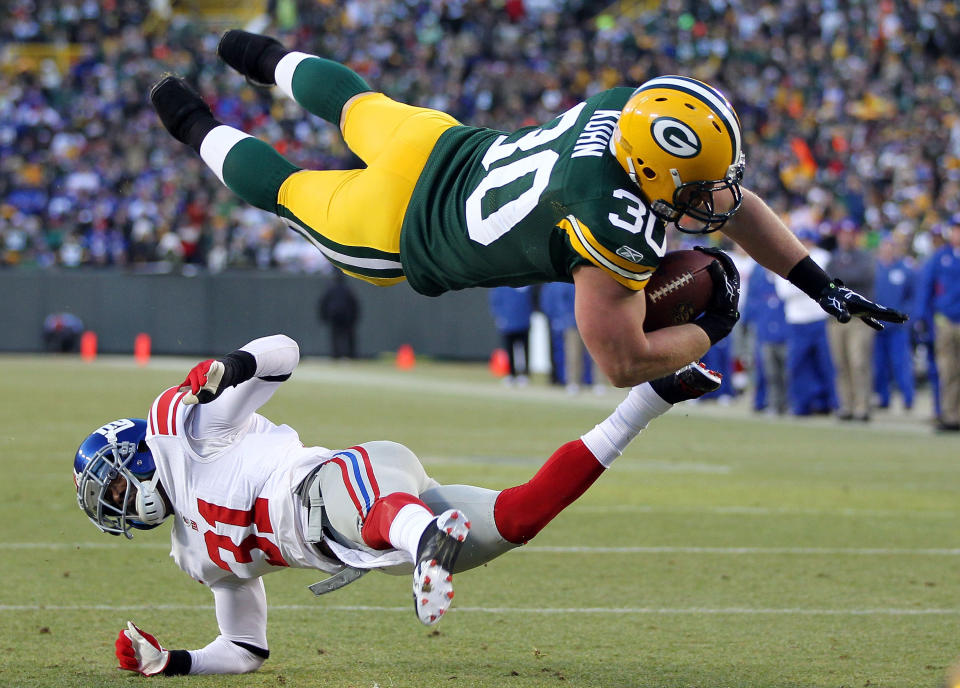 GREEN BAY, WI - JANUARY 15: John Kuhn #30 of the Green Bay Packers dives in for the touchdown over Aaron Ross #31 of the New York Giants during their NFC Divisional playoff game at Lambeau Field on January 15, 2012 in Green Bay, Wisconsin. (Photo by Jamie Squire/Getty Images)