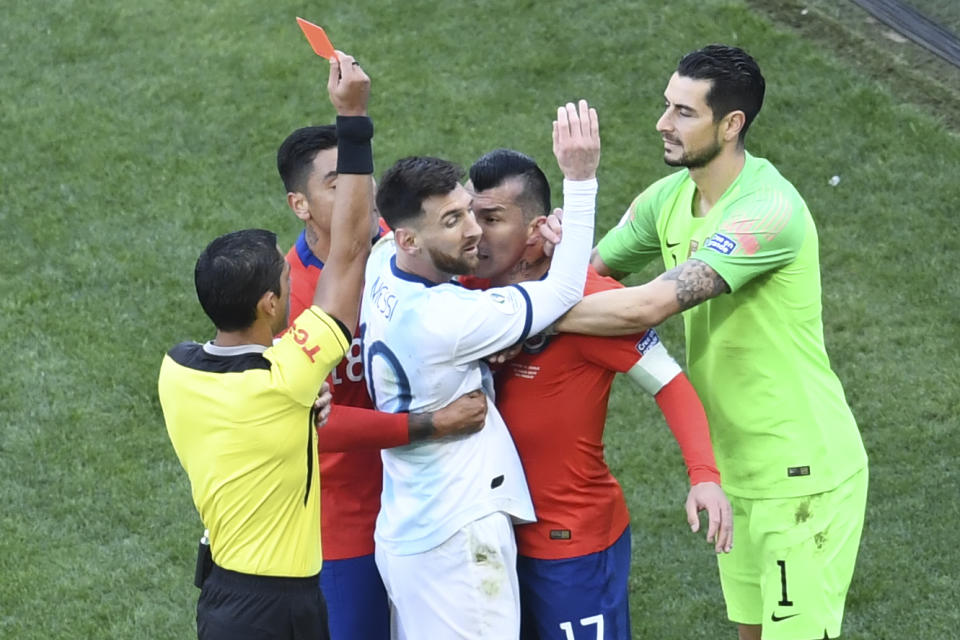 Paraguayan referee Mario Diaz de Vivar shows the red card to Argentina's Lionel Messi and Chile's Gary Medel during the Copa America football tournament third-place match at the Corinthians Arena in Sao Paulo, Brazil, on July 6, 2019. (Photo by EVARISTO SA / AFP)        (Photo credit should read EVARISTO SA/AFP/Getty Images)