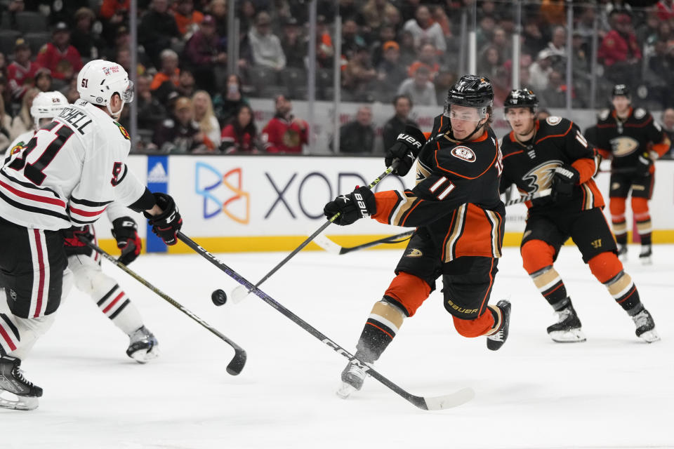 Anaheim Ducks' Trevor Zegras (11) shoots under pressure by Chicago Blackhawks' Ian Mitchell (51) during the third period of an NHL hockey game Monday, Feb. 27, 2023, in Anaheim, Calif. (AP Photo/Jae C. Hong)