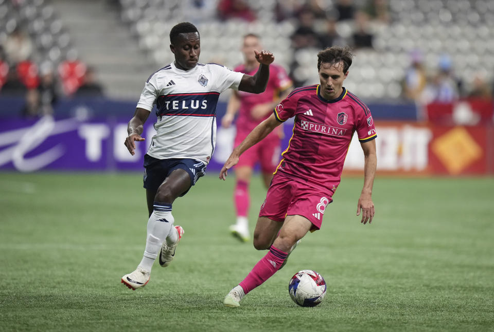 Vancouver Whitecaps' Richie Laryea, left, tries to defend against St. Louis City's Jared Stroud during the first half of an MLS soccer match Wednesday, Oct. 4, 2023, in Vancouver, British Columbia. (Darryl Dyck/The Canadian Press via AP)