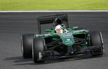 Caterham Formula One driver Kamui Kobayashi of Japan waves as he negotiates a corner during the qualifying session of the Japanese F1 Grand Prix at the Suzuka Circuit October 4, 2014. REUTERS/Toru Hanai