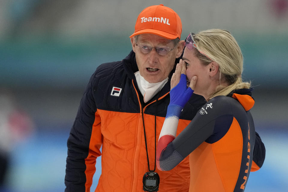 Irene Schouten of the Netherlands reacts with a coach after winning the gold medal and breaking the Olympic record in the women's speedskating 3,000-meter race at the 2022 Winter Olympics, Saturday, Feb. 5, 2022, in Beijing.(AP Photo/Ashley Landis)