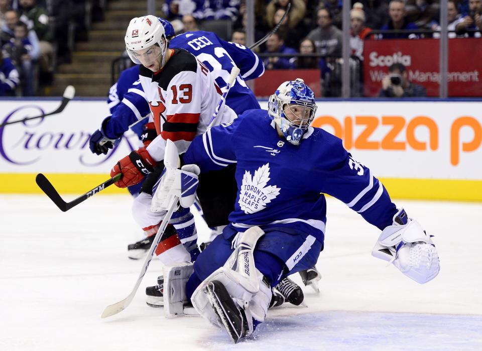 CORRECTS THAT A GOAL WAS SCORED ON THE PLAY - Toronto Maple Leafs goaltender Frederik Andersen (31) looks back at a goal, next to New Jersey Devils center Nico Hischier (13) during the third period of an NHL hockey game Tuesday, Jan. 14, 2020, in Toronto. (Frank Gunn/The Canadian Press via AP)