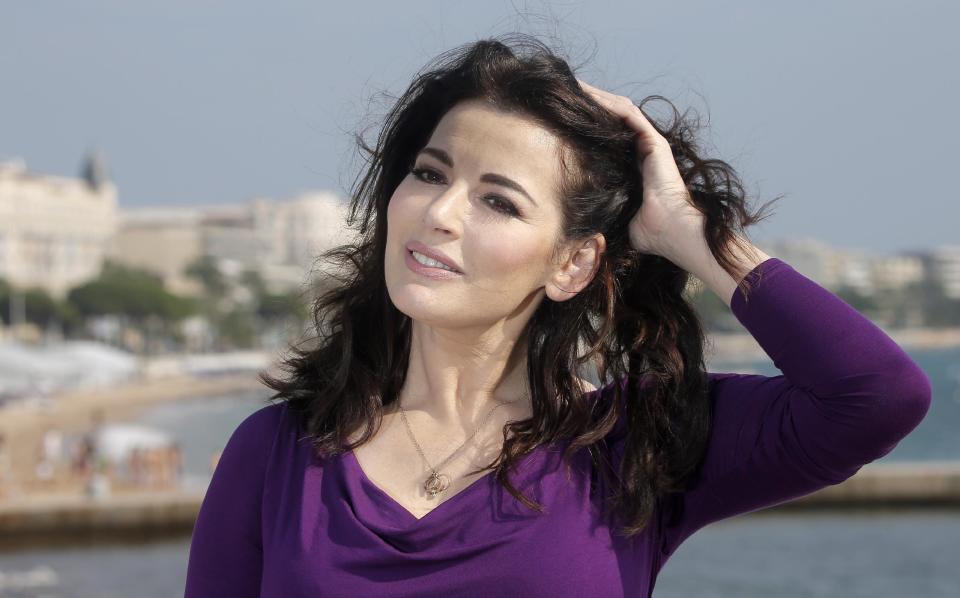FILE - In this Tuesday, Oct. 9, 2012 file photo, food writer, journalist and broadcaster, Nigella Lawson of Britain poses during the 28th International Film and Programme Market for TV, Video, Cable and Satellite in Cannes, southeastern France. In summer 2013, photos of her husband appearing to choke her surfaced. Then two former employees accused of using the couple’s credit cards for more than $1 million in fraudulent charges claiming she had sanctioned their spending to hush them up about her heavy drug use. (AP Photo/Lionel Cironneau, File)