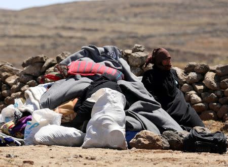 Internally displaced woman from Deraa province sits next to her belongings near the Israeli-occupied Golan Heights, in Quneitra, Syria June 21, 2018. REUTERS/Alaa al-Faqir