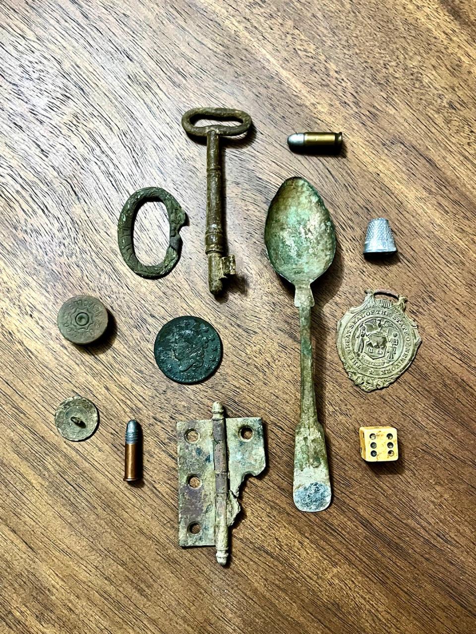 Found objects, like a spoon and coin, on a wooden table