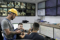 Technicians speak in the master control room at the Comvex handling and storage facility in the Black Sea port of Constanta, Romania, Tuesday, June 21, 2022. While Romania has vocally embraced the ambitious goal of turning into a main hub for the export of agricultural products from Ukraine, economic experts and port operators in the country warn that it was much easier objective to set than to actually achieve. (AP Photo/Vadim Ghirda)