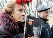 A woman holds a Nemtsov-authored book 'Confessions of the Rebel' as she lines up to attend a farewell ceremony for slain opposition leader Boris Nemtsov in Moscow, on March 3, 2015