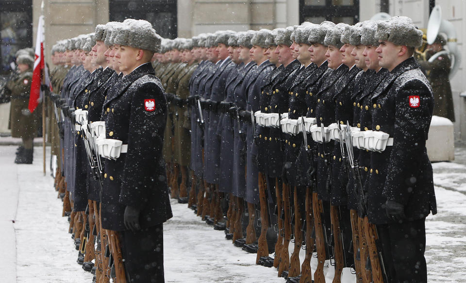 Snow falls on the troops of Poland's Guard of Honor waiting to welcome Mongolian President Tsakhia Elbegdorj in front of the Presidential Palace in Warsaw, Poland on Monday, Jan. 21, 2013. (AP Photo/Czarek Sokolowski)