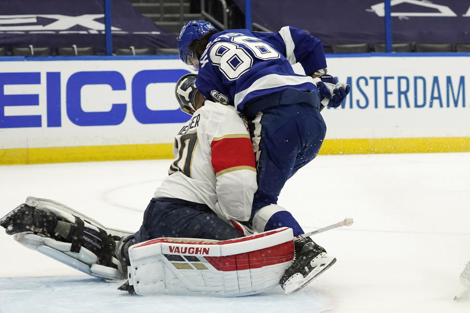 Tampa Bay Lightning right wing Nikita Kucherov (86) runs into Florida Panthers goaltender Chris Driedger (60) during the second period in Game 4 of an NHL hockey Stanley Cup first-round playoff series Saturday, May 22, 2021, in Tampa, Fla. (AP Photo/Chris O'Meara)