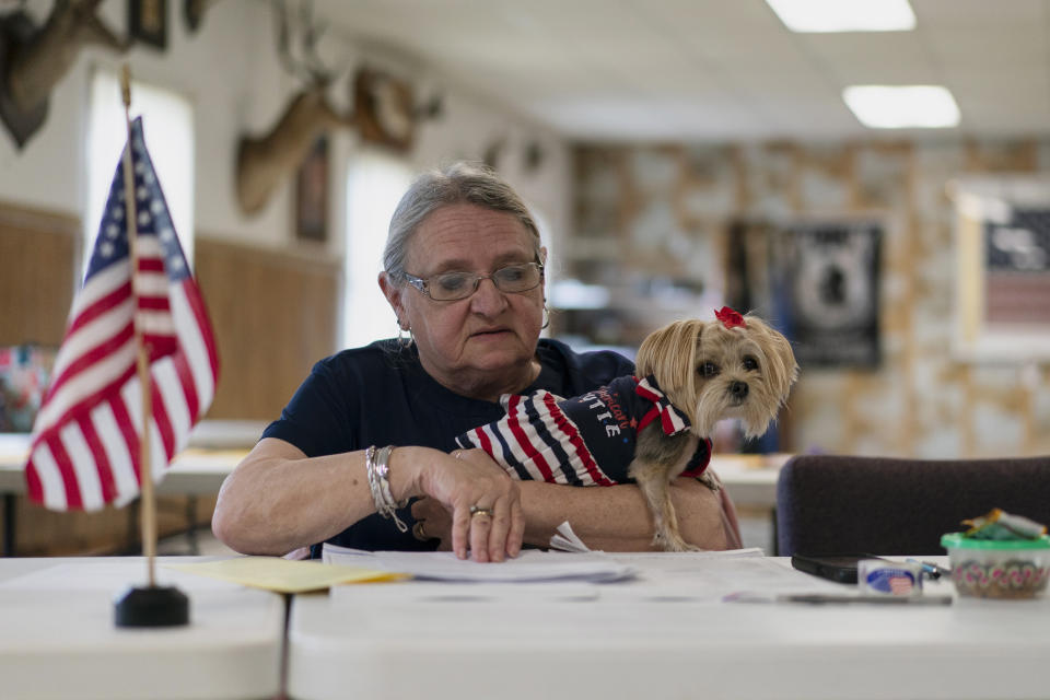 Polling place worker Donna Appleby holds her dog Daisy Mae as she waits for voters during the Pennsylvania primary election at the LSL Sportsman's club in Orrstown, Pa., Tuesday, May 17, 2022. (AP Photo/ Carolyn Kaster)