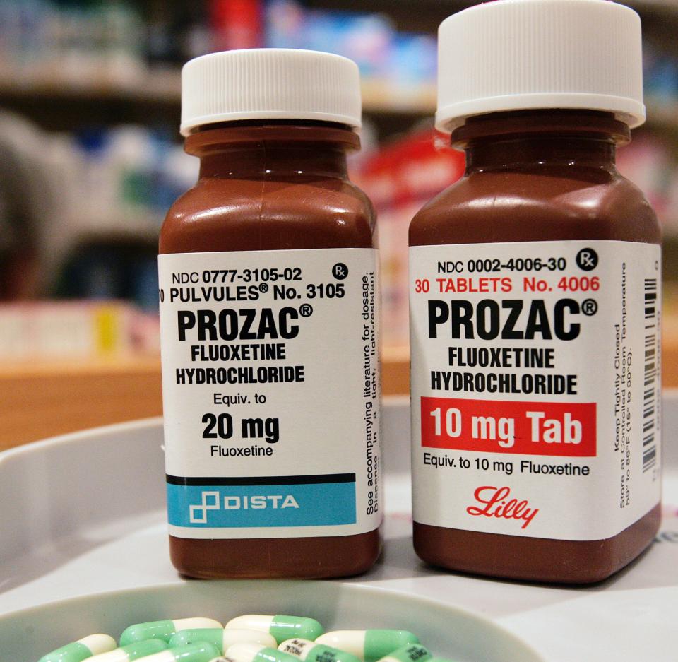 Two bottles of Prozac (fluoxetine) are seen on a pharmacy shelf.