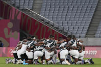 Fiji players huddle up on the pitch after winning their men's rugby sevens gold medal match against New Zealand at the 2020 Summer Olympics, Wednesday, July 28, 2021 in Tokyo, Japan. (AP Photo/Shuji Kajiyama)