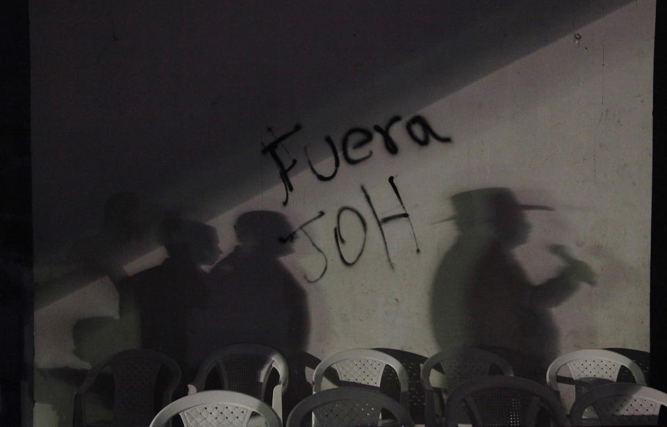 FILE - In this Feb. 3, 2018 file photo, the shadow of ousted Honduran President Manuel Zelaya is cast on a wall covered by the message "Get out JOH," referring to President Juan Orlando Hernandez, in Central Park, Tegucigalpa, Honduras. Since then-President Manuel Zelaya was ousted in a coup in 2009, the country’s political situation has been tense. The polarization increased after the November 2017 election in which current President Juan Orlando Hernandez was re-elected in a result marred by electoral irregularities, and denounced by his opponent as outright fraud. Extensive protests over the election were repressed with “indiscriminate and excessive use of force,” according to the Inter-American Commission on Human Rights. (AP Photo/Fernando Antonio, File)