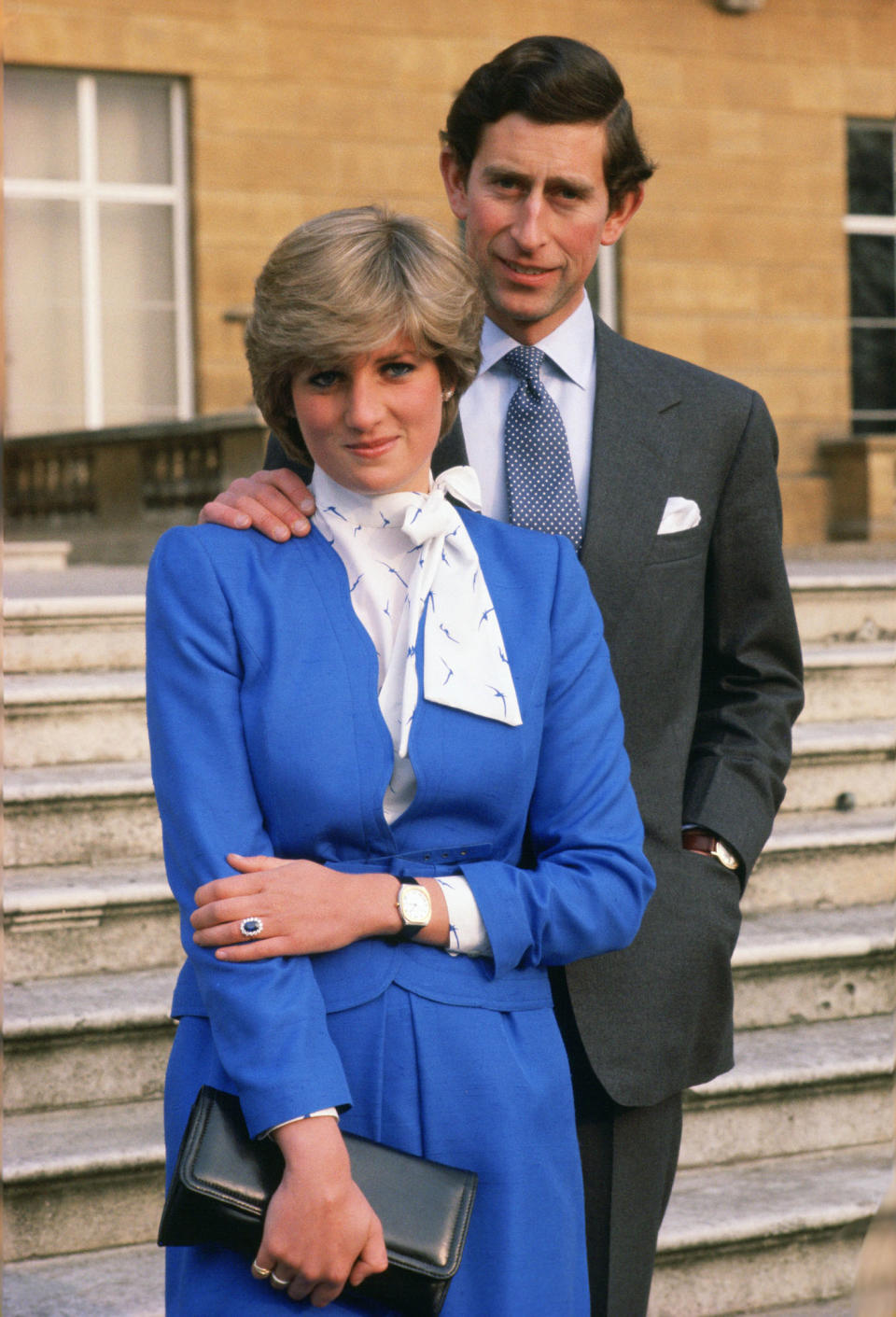 Diana enthüllt neben Prince Charles ihren Saphir-Verlobungsring in einem royalblauen Ensemble vor dem Buckingham Palace (Bild: Getty Images/Tim Graham)