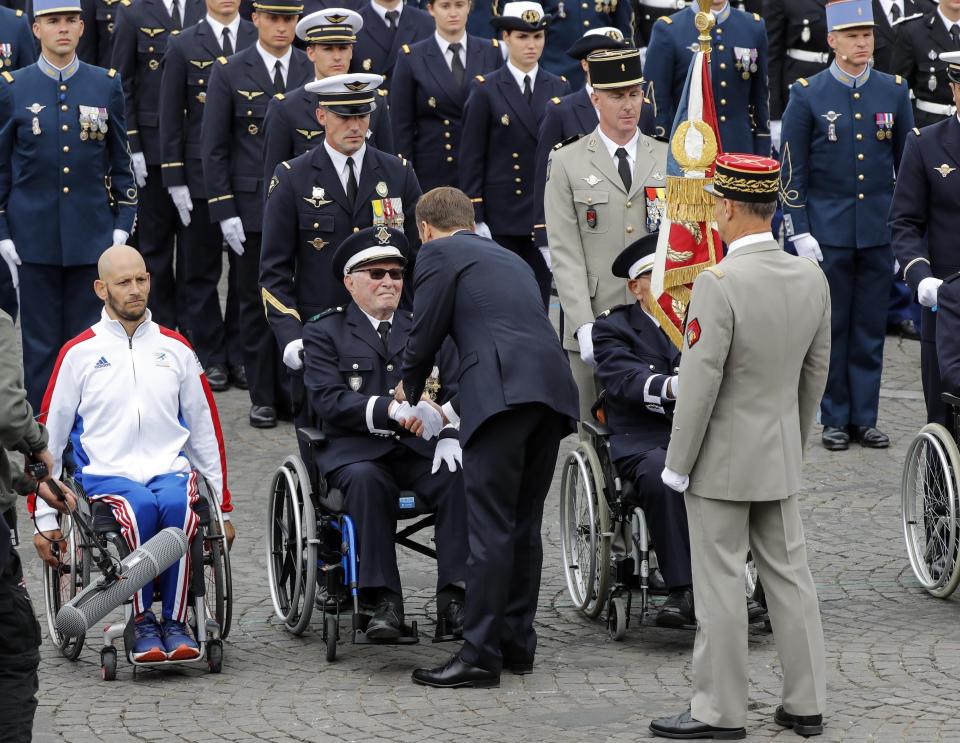 French President Macron shakes hands with a 89 year old veteran who was wounded in French Indochina after the Bastille Day parade in Paris, France, Sunday July 14, 2019. (AP Photo/Michel Euler)