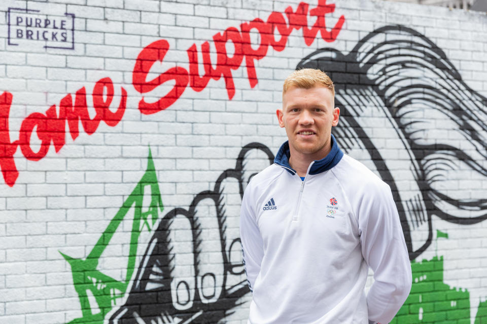 Cross poses in front of the Cardiff mural he unveiled as part of the Purplebricks Home Support Art Relay.