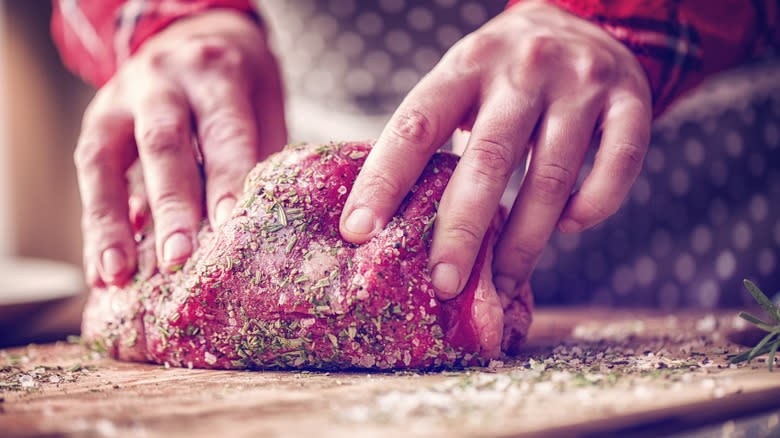 rubbing herbs and spices on roast
