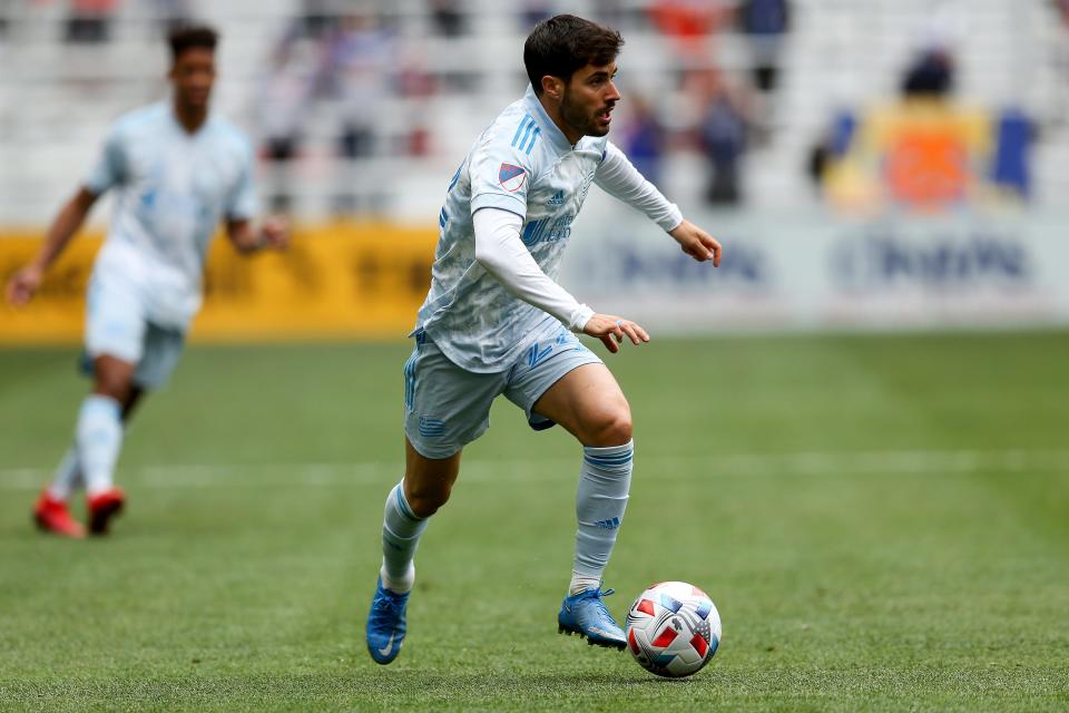 New England Revolution midfielder Carles Gil (22) dribbles the ball forward during the first half of an MLS soccer match against the FC Cincinnati, Saturday, May 29, 2021, at TQL Stadium in Cincinnati. 