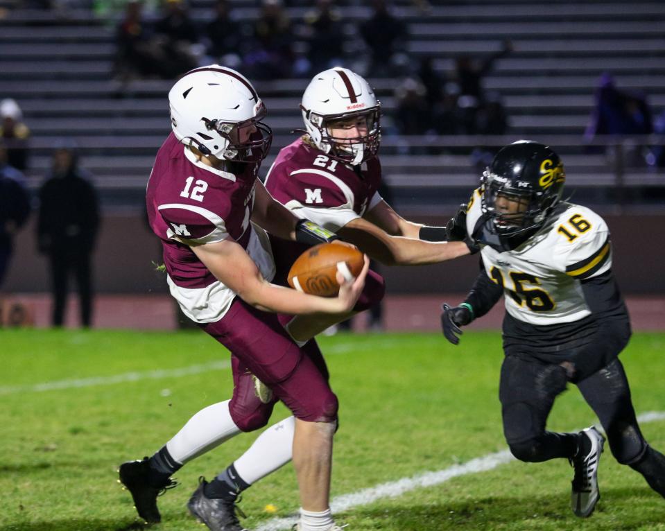 Mishawaka's Brady Fisher (12) scores a touchdown in front of Fort Wayne Snider's De'Marreia Stephens (16) during Friday night’s Regional game at Mishawaka.