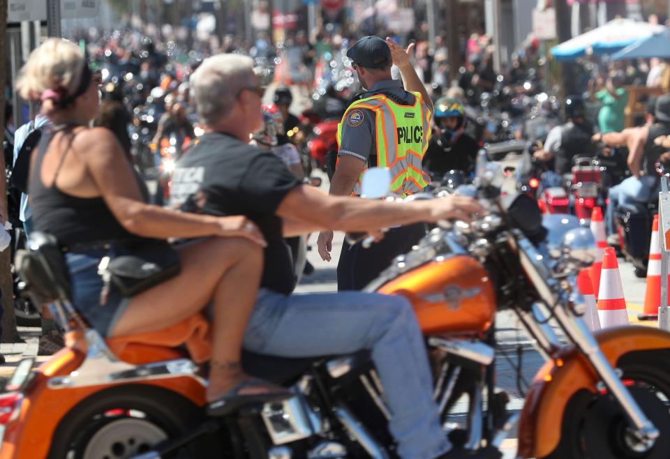 A Daytona Beach police officer keeps traffic moving along Main Street on Saturday as Biketoberfest shifts into high gear in Daytona Beach. This year's 30th anniversary edition of the four-day event offered a welcome boost to area businesses in the wake of damages and disruptions from Tropical Storm Ian.