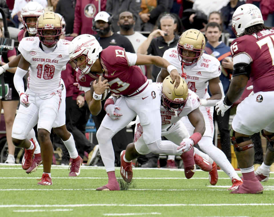 Florida State quarterback Jordan Travis (13) gets tackled by Boston College linebacker Kam Arnold (5) during the first half of an NCAA college football game, Saturday, Sept. 16, 2023 in Boston. (AP Photo/Mark Stockwell)