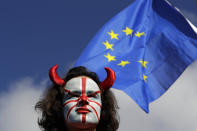 An anti-Brexit protestor and an EU flag are seen during protest in London, Saturday, Oct. 19, 2019. Britain's Parliament is set to vote in a rare Saturday sitting on Prime Minister Boris Johnson's new deal with the European Union, a decisive moment in the prolonged bid to end the Brexit stalemate. Various scenarios may be put in motion by the vote. (AP Photo/Kirsty Wigglesworth)