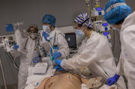 A medical team of the new Nurse Isabel Zendal Hospital perform a fiberoptic bronchoscopy to a patient of the COVID-19 ICU ward in Madrid, Spain, Monday, Jan. 18, 2021. As the coronavirus curve of contagion turned increasingly vertical after Christmas and New Year's, the Zendal has been busy. On Monday, 392 virus patients were being treated, more than in any other hospital in the Madrid region. (AP Photo/Bernat Armangue)