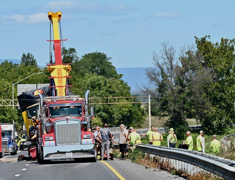 A tow truck works at the scene of a fatal crash that involved four tractor-trailers and two passenger vehicles Friday morning on Interstate 81 north of Hagerstown. At least one person was killed and multiple people were injured.