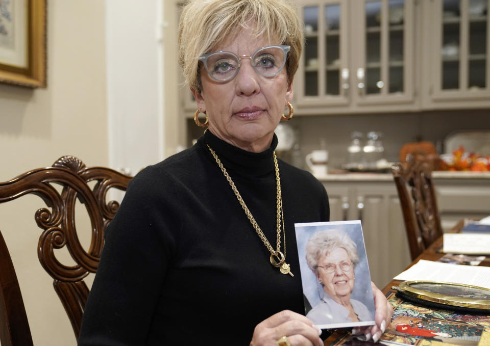 Shanon Dion poses holding a photo of her mother Doris Gleason in Carrolton, Texas, Wednesday, Nov. 3, 2021. Gleason was one of 18 women in the Dallas area that Billy Chemirmir is charged with capital murder and he is suspected in several more deaths. Most of the deaths happened at upscale independent living communities for older people, where Chemirmir has been accused of forcing his way into apartments or posing as a handyman, and in a couple instances was even caught trespassing. (AP Photo/LM Otero)