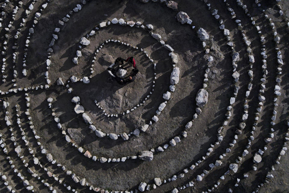 FILE - A group of Brazilian tourists hold hands standing in a circle at the heart of a stone labyrinth in the Pueblo Encanto spiritual theme park in Capilla del Monte, Argentina, Wednesday, July 19, 2023. In the pope's homeland of Argentina, Catholics have been renouncing the faith and joining the growing ranks of the religiously unaffiliated. Commonly known as the "nones," they describe themselves as atheists, agnostics, spiritual but not religious, or simply: "nothing in particular." (AP Photo/Natacha Pisarenko, File)