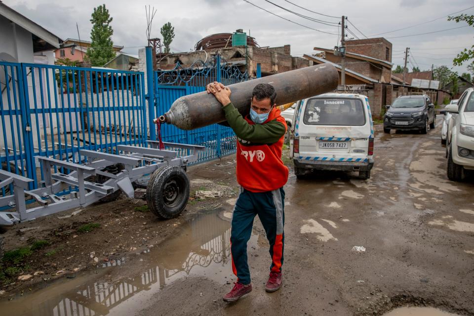 Showkat Ahmed War carries an empty oxygen cylinder to get it refilled at a gas supplier facility in Srinagar, Kashmir, which is controlled by India, on May 11, 2021. War traveled about 40 miles to refill the cylinder needed for his ailing father due to the huge demand for oxygen after the surge in COVID-19 cases.