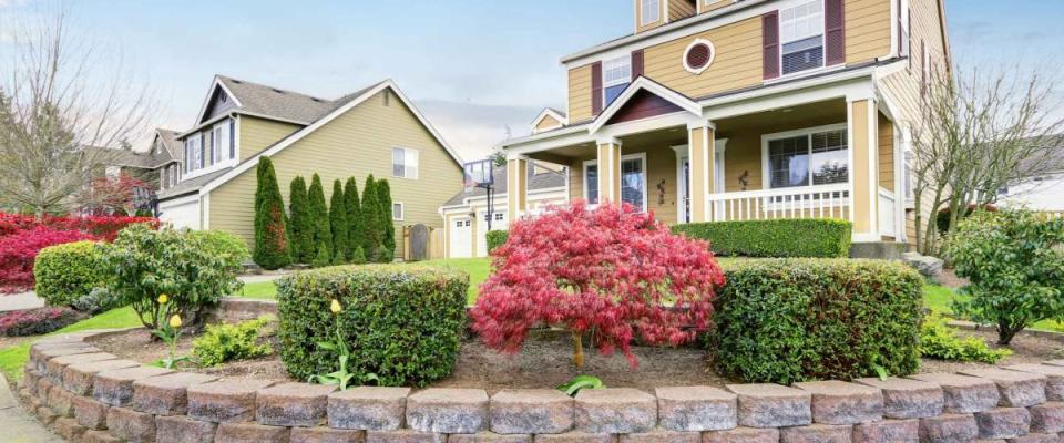 American house exterior with covered porch and columns. Beautiful curb appeal and perfect landscape design. Northwest, USA