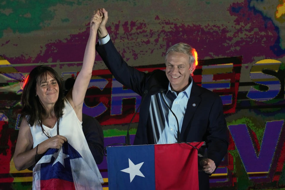 Republican Party presidential candidate Jose Antonio Kast stands before supporters with his wife Maria Pia Adriasola at his campaign headquarters after polls closed in Santiago, Chile, Sunday, Nov. 21, 2021. (AP Photo/Esteban Felix)
