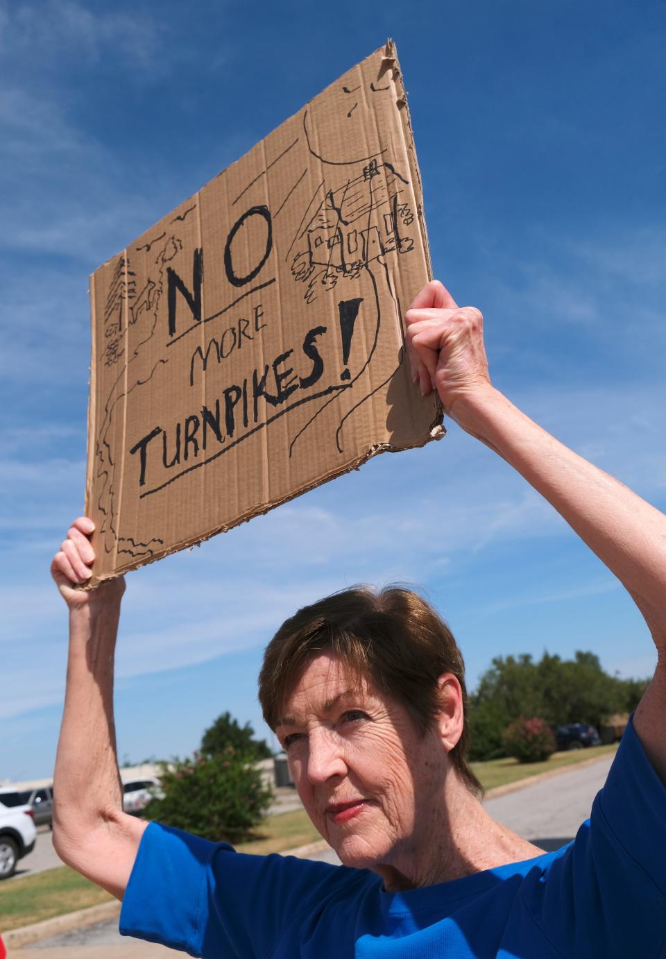 Norman resident Linda Evans holds her homemade sign showing her discontent. Members of Pike Off OTA, a group opposed to portions of the ACCESS turnpike expansion, held a protest on Aug. 30, 2022, outside a fundraiser for Gov. Kevin Stitt at the Association of Oklahoma General Contractors.