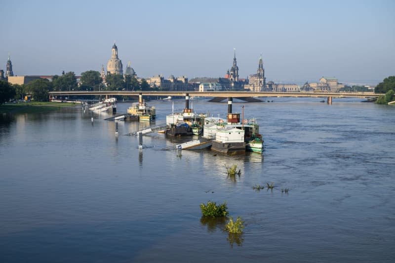 The jetties for the ships of the Saechsische Dampfschifffahrt are surrounded by the high water of the Elbe, as the old town and the partially collapsed Carola Bridge seen in the background. Robert Michael/dpa