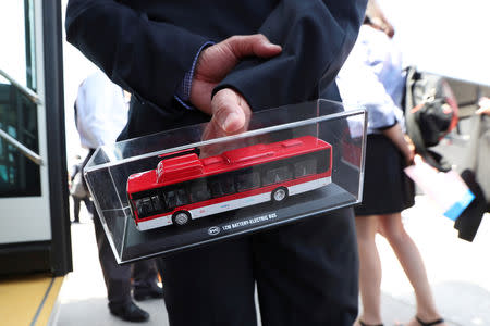 A man holds a model of an electric bus as Chile's government launches the new fleet of electric buses for public transport in Santiago, Chile December 13, 2018. REUTERS/Ivan Alvarado