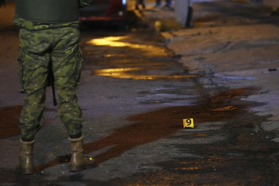 A soldier stands guard at the scene where a vehicle blew up outside the Women's and Human Rights Ministry building in Quito, Ecuador, late Wednesday, Aug. 30, 2023. The building used to be the location of the government’s National Service for Attention for People Deprived of Liberty (SNAI), which runs the jail system. (AP Photo/Dolores Ochoa)