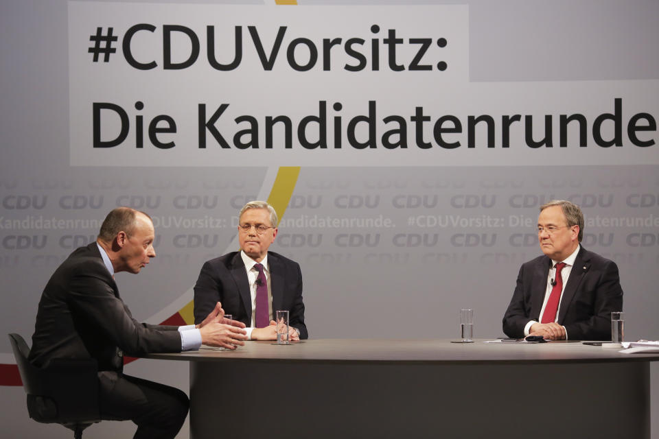 FILE - In this Dec. 14, 2020 file photo, the three candidates for the chairmanship of the Christian Democratic Union party, CDU, Friedrich Merz, left, Norbert Roettgen, center, and Armin Laschet, right, take part in a discussion at the party's headquarters in Berlin. German Chancellor Angela Merkel's center-right party, the Christian Democratic Union, CDU, is choosing a new leader on the weekend Saturday Jan. 16 and Sunday Jan. 17, 2021, a decision that will help determine who succeeds Merkel at the helm of the European Union's biggest economy after a 16-year reign.Background slogan reads: 'CDU Chairmanship: The candidate round'. (AP Photo/Markus Schreiber, File)