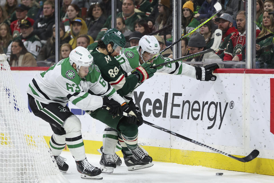 Dallas Stars right wing Evgenii Dadonov, left, Stars defenseman Ryan Suter (20) and Minnesota Wild center Frederick Gaudreau (89) compete for the puck during the second period of an NHL hockey game Monday, Jan. 8, 2024, in St. Paul, Minn. (AP Photo/Matt Krohn)