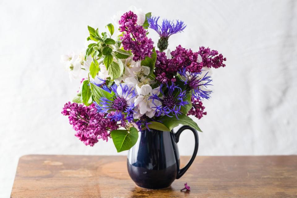 Purple flower arrangement in black vase