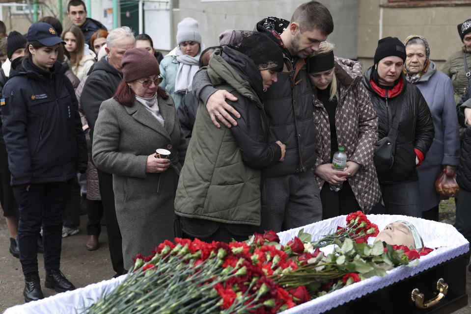 Family members of Vitaliy Alimov, his mother Maria and his wife Natalia, mourn over his body before his funeral in Bilhorod-Dnistrovskyi, Ukraine, Monday March 18, 2024. Alimov, a firefighter, was killed in the Russian attack on Odesa on Friday March 15. (AP Photo/Victor Sajenko)