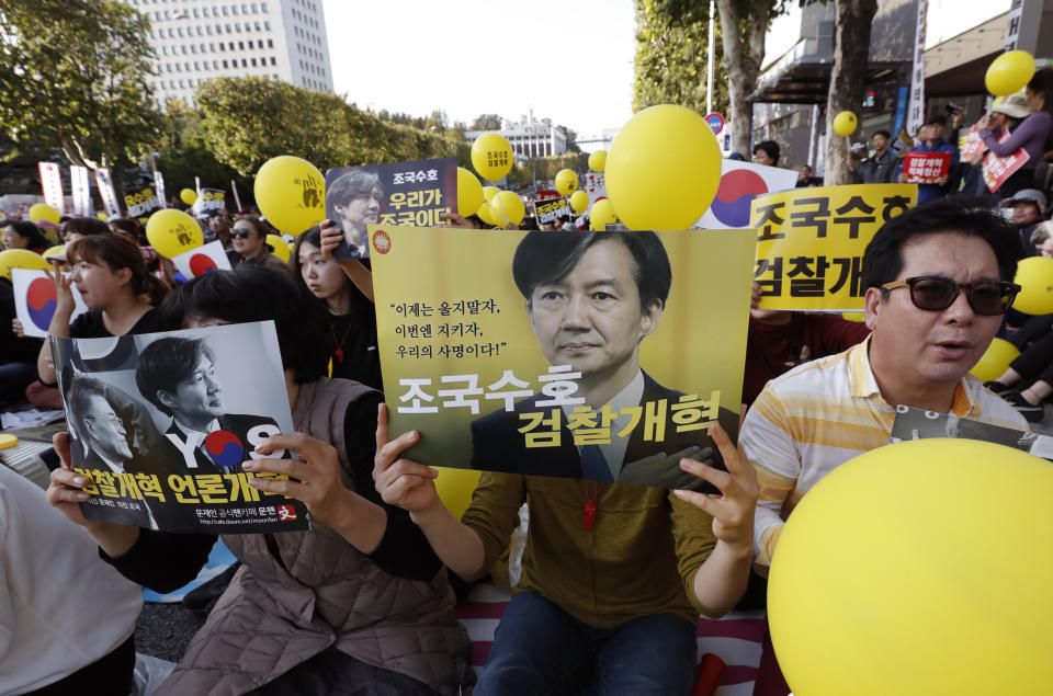 Pro-government supporters hold signs with pictures of Justice Minister Cho Kuk, before a rally supporting Cho in front of Seoul Central District Prosecutors' Office in Seoul, South Korea, Saturday, Oct. 12, 2019. Tens of thousands of government supporters gathered in South Korea's capital for the fourth straight Saturday to show their support for President Moon Jae-in's justice minister, who is enmeshed in an explosive political scandal that has polarized the nation. The letters read "Reform the Prosecution" and "Protect Cho Kuk". (AP Photo/Lee Jin-man)