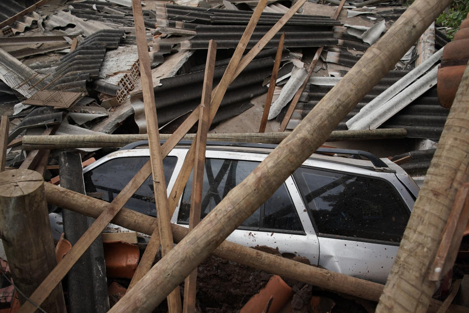 A car lies covered in debris after a dam collapse near Brumadinho, Brazil, Saturday, Jan. 26, 2019. Rescuers in helicopters on Saturday searched for survivors while firefighters dug through mud in a huge area in southeastern Brazil buried by the collapse of a dam holding back mine waste, with at least nine people dead and up to 300 missing. (AP Photo/Leo Correa)