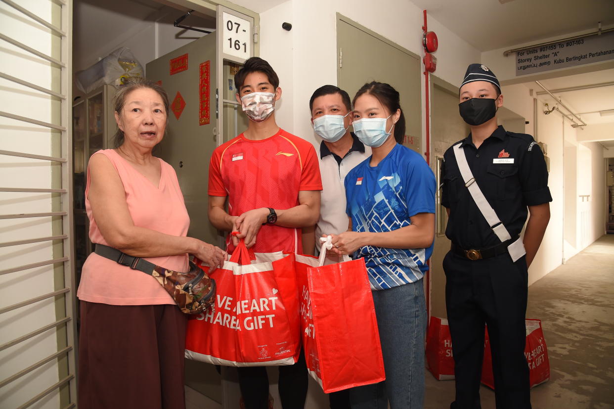 Badminton world champion Loh Kean Yew (second from left) and fellow national shuttler Yeo Jia Min (second from right) deliver food hampers to beneficiaries for Boys' Brigade Share-a-Gift 2021 event. (PHOTO: Boys' Brigade)