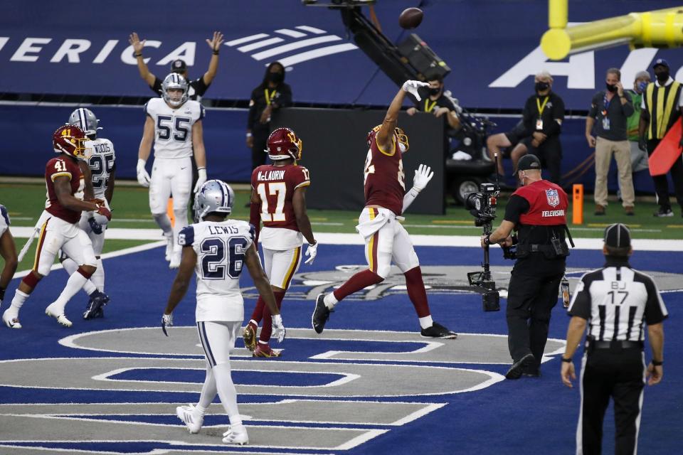 Dallas Cowboys' Jourdan Lewis (26), Leighton Vander Esch (55) and others look on as Washington Football Team tight end Logan Thomas (82) throws the ball into the seats after scoring a touchdown in the first half of an NFL football game in Arlington, Texas, Thursday, Nov. 26, 2020. (AP Photo/Roger Steinman)
